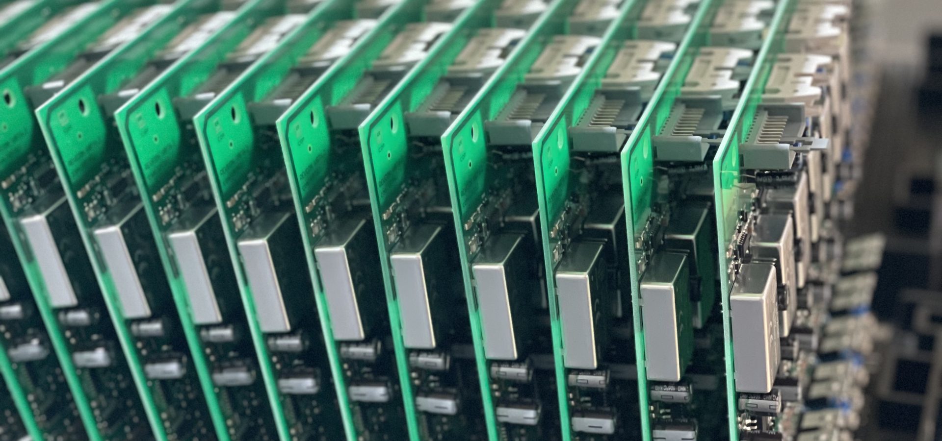 Bestückte SMD-Baugruppen in einem Magazin, silberne Schirmungen in einer Reihe