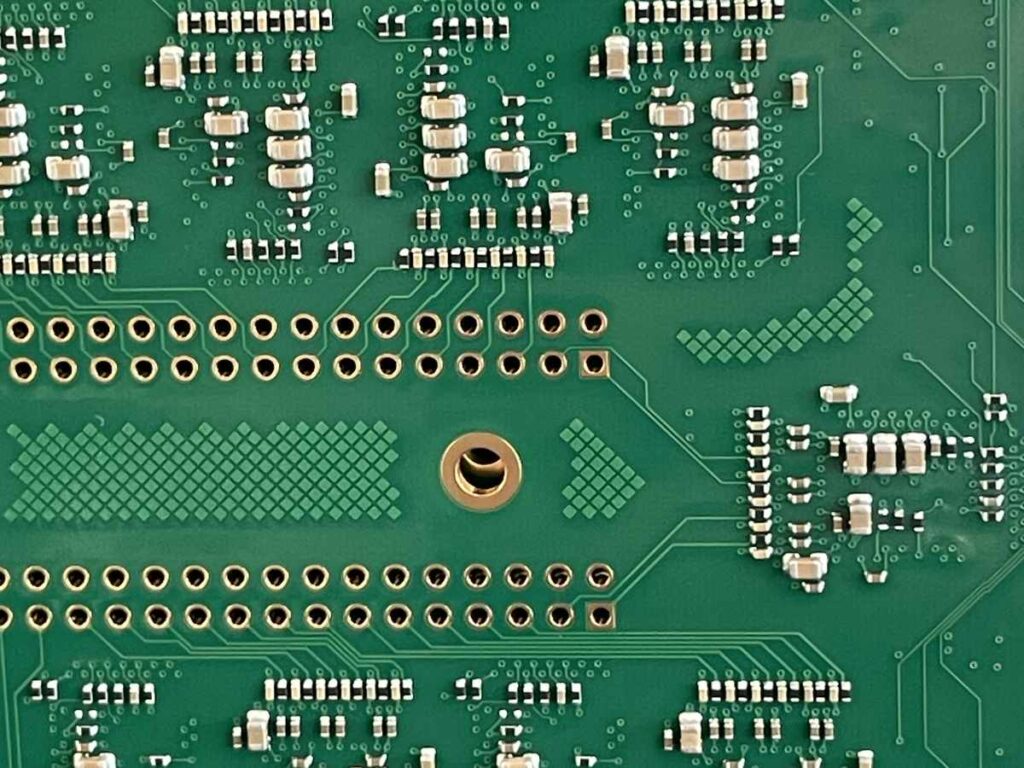 Nahaufnahme einer bestückten Leiterplatte mit SMD-Bauteilen und Durchkontaktierungen