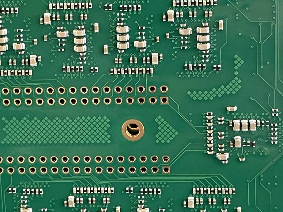 Nahaufnahme einer bestückten Leiterplatte mit SMD-Bauteilen und Durchkontaktierungen